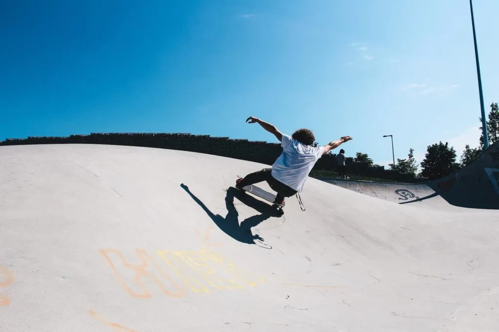 Deskorolkarz robi trik w skateparku. Surfskate Curfboard SE.